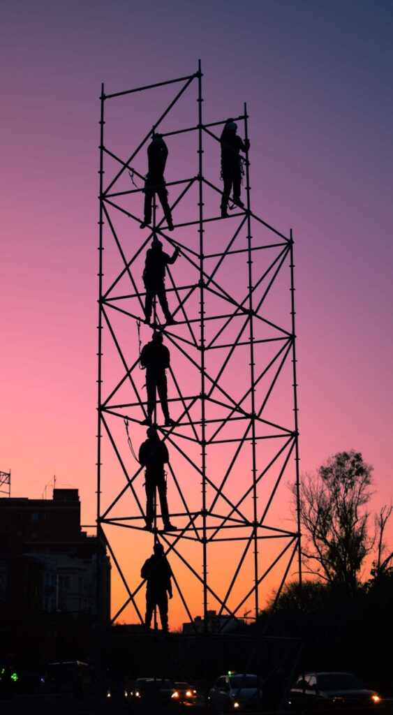 People On A Scaffolding Under A Purple Sky